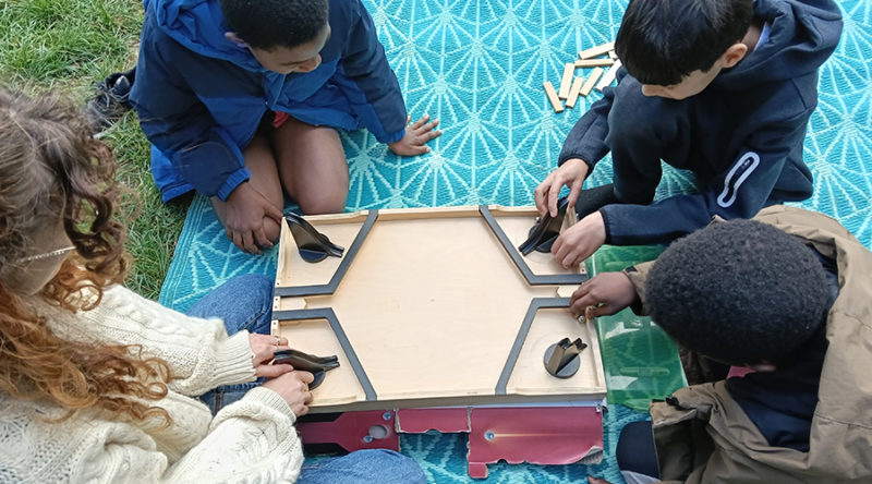 la ludo prend l'air, enfants et animatrice en train de jouer avec un jeu de la ludothèque